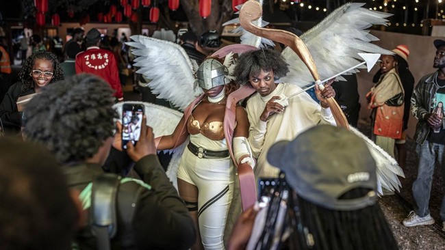 Cosplayer and overall winner of the cosplay competition Yvonne Chockey (C) takes pictures with a crowd of fans following her win while cosplaying as Angewomon, a character from the popular Digimon anime series, during the Otamatsuri convention in Nai