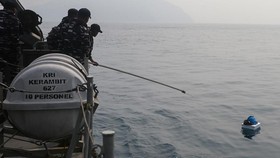Prajurit TNI AL awak KRI Kerambit-627 berusaha mengangkat benda yang ditemukan mengapung saat operasi pencarian kapal cepat yang hilang kontak di Perairan Selat Sunda, Kabupaten Lampung Selatan, Lampung, Jumat (11/9/2026). Tim SAR gabungan memperluas