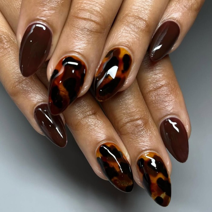 Tortoise talons memadukan warna coklat chocolate dengan motif tortoiseshell untuk menciptakan manicure yang rich dan elegan. Desain ini cocok untuk kamu yang menyukai warna gelap serta nail art dengan tekstur visual yang menarik./ Foto: instagram.com/brownluxenails