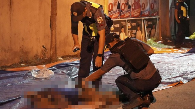 EDITORS NOTE: Graphic content / Police search a body at the scene of a shooting incident outside a polling station in Cotabato City early on September 14, 2026, ahead of the first election to be held in the Bangsamoro Autonomous Region in Muslim Mind