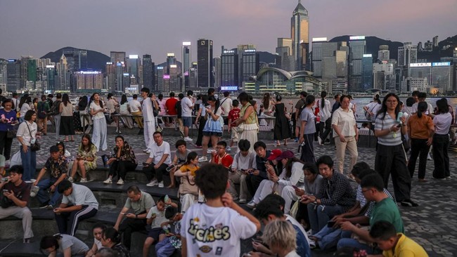 Tourists watch the sunset over Victoria Harbour in Hong Kong, China, July 24, 2026. REUTERS/Tyrone Siu