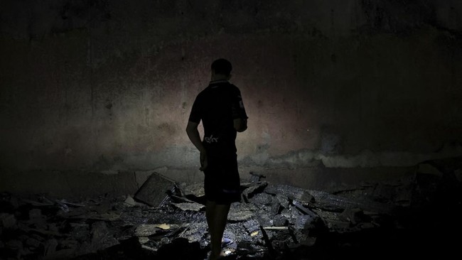 A migrant stands amidst debris from a fire that broke out, burning improvised migrant shelters, following recent mass crossings of migrants from Morocco to Ceuta, in Ceuta, Spain, September 10, 2026. REUTERS/Max Cavallari
