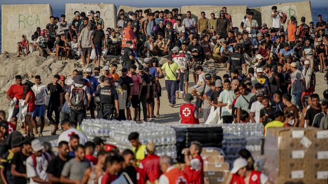 People gather around the Red Cross, waiting for food distribution at Trampolin Beach following the mass crossing of migrants through the border with Morocco, in Ceuta, Spain, September 12, 2026. REUTERS/Ana Beltran