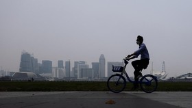A cyclist wearing a protective mask rides along the bayfront with the city skyline shrouded in haze as smoke from regional forest fires reduces visibility across the island city-state, in Singapore, September 14, 2026. REUTERS/Suhaimi Abdullah