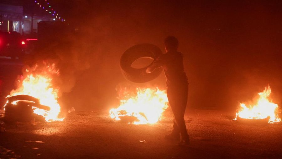 Seorang pengunjuk rasa di Aleppo membakar ban untuk memprotes kenaikan harga bahan bakar di Suriah, di jalan raya antara Aleppo dan Turki, Suriah, 13 September 2026. Seorang pengunjuk rasa di Aleppo membakar ban untuk memprotes kenaikan harga bahan bakar di Suriah, di jalan raya antara Aleppo dan Turki, Suriah, 13 September 2026.