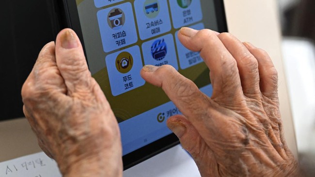 This picture taken on August 13, 2026 shows an elderly woman using a tablet computing device during a government-organised digital survival training at a senior community centre in Suwon. Age gaps in digital literacy are a global concern, yet the gul