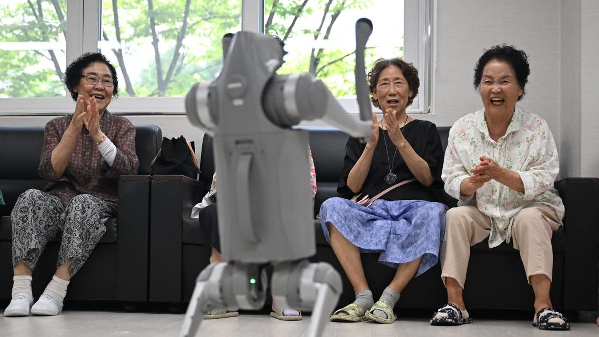 This picture taken on August 13, 2026 shows elderly people playing with a robot dog during a government-organised digital survival training at a senior community centre in Suwon. Age gaps in digital literacy are a global concern, yet the gulf has wid