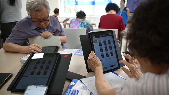 This picture taken on August 13, 2026 shows elderly people using tablet PCs during a government-organised digital survival training at a senior community centre in Suwon. Age gaps in digital literacy are a global concern, yet the gulf has widened mas