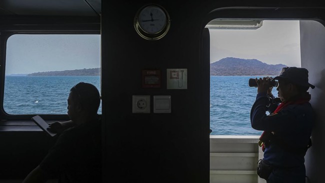 Tim SAR gabungan menggunakan binokuler dari atas KN SAR 247 Tetuka saat melakukan pencarian kapal cepat beserta rombongan jurnalis yang hilang kontak di Perairan Selat Sunda, sekitar kawasan Taman Nasional Ujung Kulon (TNUK),Pandeglang, Banten, Kamis