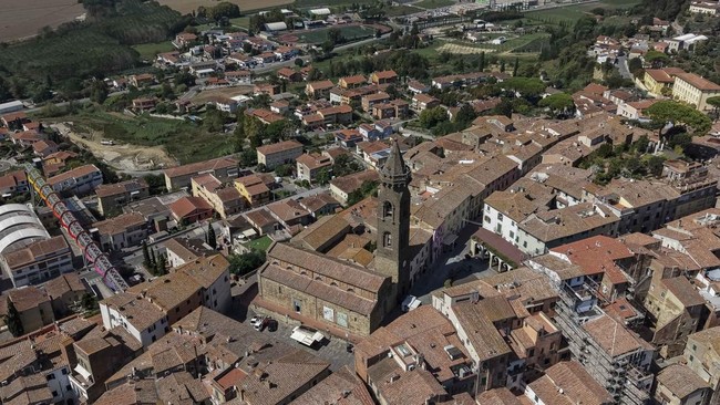 A drone view shows the historic centre of Peccioli, with the bell tower of San Verano and the