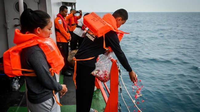 Sejumlah anggota keluarga dan kerabat dari salah satu jurnalis yang hilang kontak berfoto bersama usai tabur bunga di Pantai Pagedongan