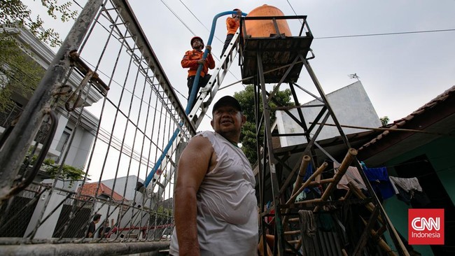 Personel BPBD Jakarta Selatan mengisi air ke dalam ember milik warga yang terdampak kekeringan di Lenteng Agung, Jakarta, Jumat (18/9/2026)