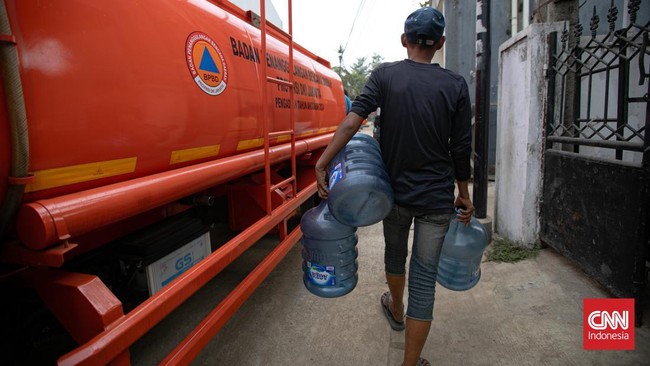 Personel BPBD Jakarta Selatan mengisi air ke dalam ember milik warga yang terdampak kekeringan di Lenteng Agung, Jakarta, Jumat (18/9/2026)