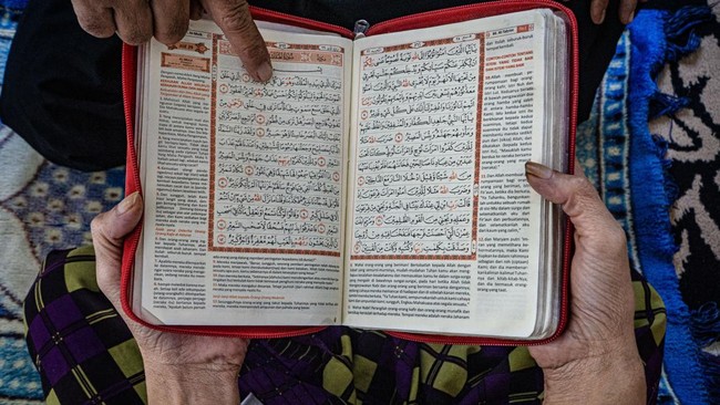 Petugas memandu pasien dengan gangguan jiwa membaca Al Quran.