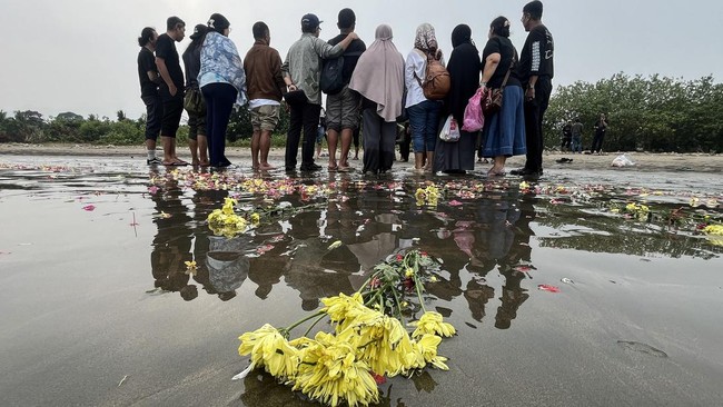 Sejumlah anggota keluarga dan kerabat dari salah satu jurnalis yang hilang kontak berfoto bersama usai tabur bunga di Pantai Pagedongan