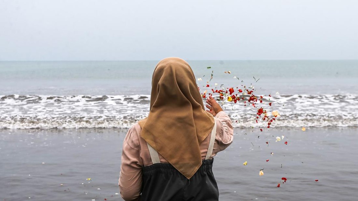 Sejumlah anggota keluarga dan kerabat dari salah satu jurnalis yang hilang kontak berfoto bersama usai tabur bunga di Pantai Pagedongan