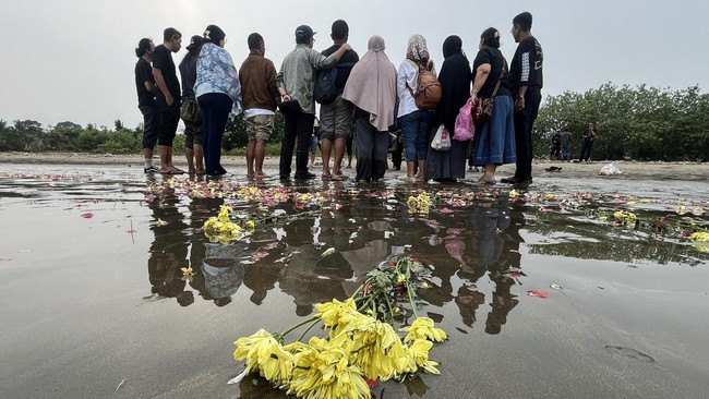 Sejumlah anggota keluarga dan kerabat dari salah satu jurnalis yang hilang kontak berfoto bersama usai tabur bunga di Pantai Pagedongan, Pandeglang.