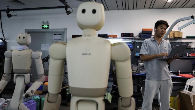 An engineer works next to Spirit AI's Moz2 robots at a testing area, at the company's headquarters in Beijing, China, September 17, 2026. REUTERS/Tingshu Wang