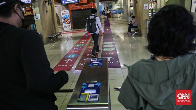 Sejumlah calon penumpang TransJakarta melintasi jalur pemandu di Halte Blok M, Melawai, Jakarta, Senin (21/9). (CNN Indonesia/Febria Adha L).