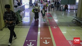 Sejumlah calon penumpang TransJakarta melintasi jalur pemandu di Halte Blok M, Melawai, Jakarta, Senin (21/9). (CNN Indonesia/Febria Adha L).