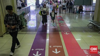 Sejumlah calon penumpang TransJakarta melintasi jalur pemandu di Halte Blok M, Melawai, Jakarta, Senin (21/9). (CNN Indonesia/Febria Adha L).