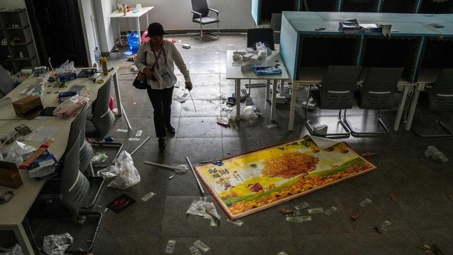 A person walks inside a building of the Legend Innovation Co., Ltd., also known as Meun Chey Commercial City or Legend Park, a site linked to online scam operations and forced labour abuses, in Tbong Wat village, Krabao commune, Komchay Mea district,