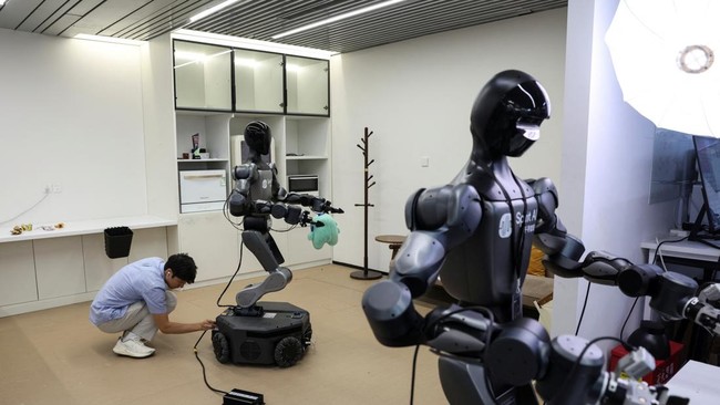 An engineer plugs in a Moz1 robot at a demonstration area in the headquarters of Spirit AI in Beijing, China, September 17, 2026. REUTERS/Tingshu Wang