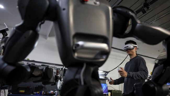 An engineer wearing VR goggles uses a controller to operate a Spirit AI's Moz1 robot, at a testing area in the companys headquarters in Beijing, China September 17, 2026. REUTERS/Tingshu Wang