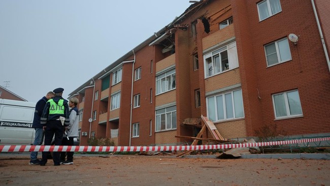 Emergency services personnel stand outside a damaged residential building following what authorities described as a Ukrainian drone strike, amid the Russia-Ukraine conflict in Sofyino settlement in the Ramensky district of the Moscow region, Russia,