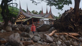 Warga berada di antara material banjir bandang di Arosuka, Kabupaten Solok, Sumatera Barat, Selasa (22/9/2026). Banjir bandang yang menerjang kawasan perkantoran di pusat kabupaten pada Senin (21/9) malam itu juga memutus akses jalan nasional dan men