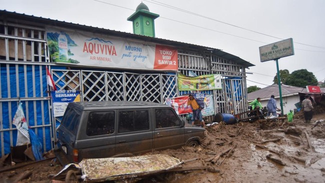 Warga mengecek kondisi kendaraan yang terendam material banjir bandang di Arosuka, Kabupaten Solok, Sumatera Barat, Selasa (22/9/2026). Banjir bandang yang menerjang kawasan perkantoran di pusat kabupaten pada Senin (21/9) malam itu juga memutus akse