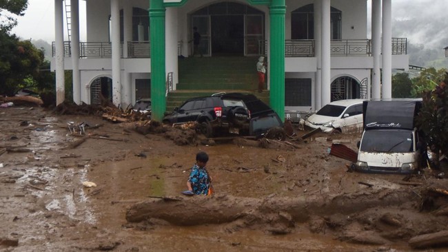 Warga mengecek kondisi kendaraan yang terendam material banjir bandang di Arosuka, Kabupaten Solok, Sumatera Barat, Selasa (22/9/2026). Banjir bandang yang menerjang kawasan perkantoran di pusat kabupaten pada Senin (21/9) malam itu juga memutus akse