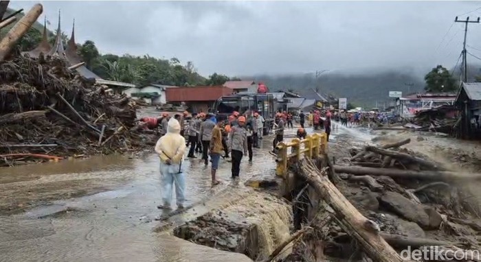 Proses perbaikan badan jalan yang dipenuhi banjir bandang di Solok, Sumbar.