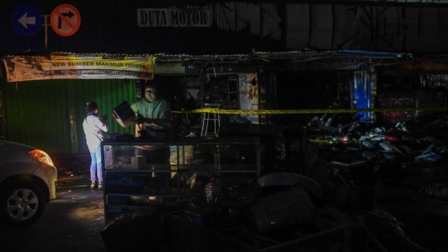 Pemilik bengkel dan toko onderdil mobil memilah dagangannya untuk diamankan usai kebakaran melanda kiosnya di Pasar Mobil Kemayoran, Jakarta, Senin (21/9/2026). Kebakaran yang disebabkan akibat korsleting listrik tersebut menghanguskan tiga kios dan