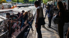 Commuters disembark from the Khlong Saen Saep boat service that runs along the Saen Saep Canal in Bangkok on September 21, 2026. (Photo by ANTHONY WALLACE / AFP)