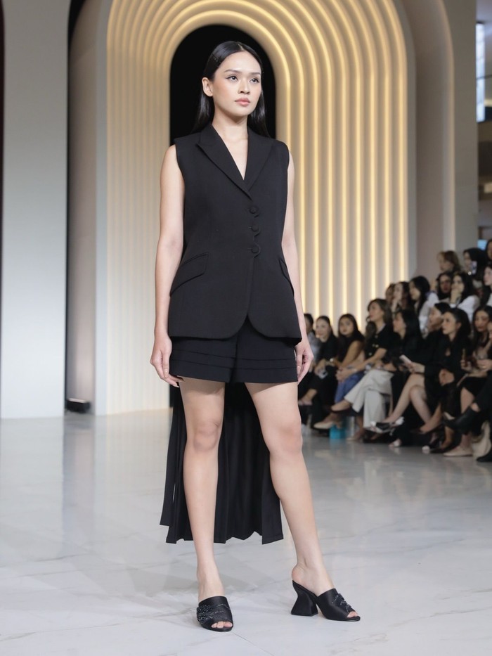 Tak kalah menarik, koleksi ini menampilkan blazer tanpa lengan yang beri aksen pleated train, lalu dipadukan dengan tailored shorts. Dari depan, menampilkan kesan yang simple dan fit body, lalu bagian belakangnya menambah sisi anggun dan bergaya. (Foto: Dok. Senayan City)