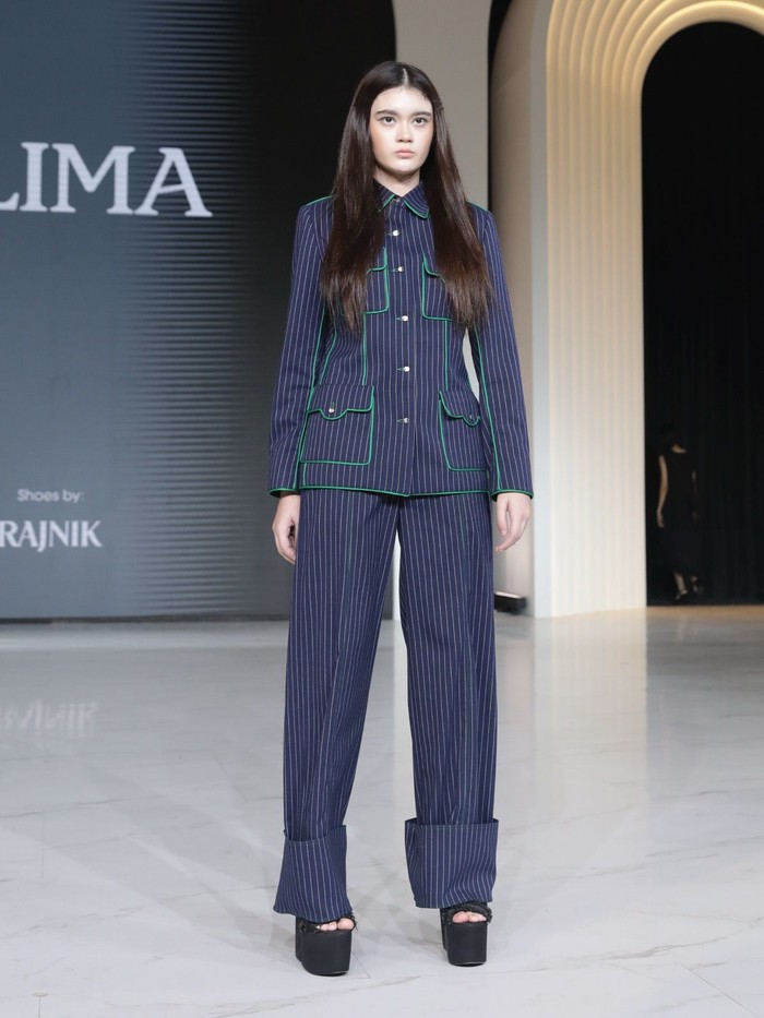 Menariknya, ada juga koleksi bahan denim stripes. Atasannya dibuat seperti kemeja dengan empat kantong, lalu diberi tambahan lis hijau yang kontras. Sementara itu, celananya masih potongan wide-leg longgar dengan lipatan bawah yang lebar. (Foto: Dok. Senayan City)