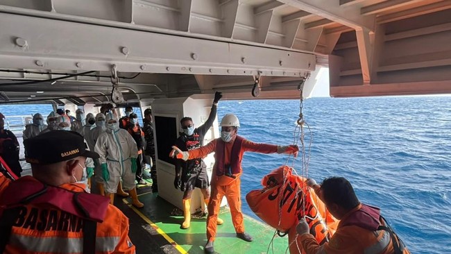 This handout photo taken and released on September 21, 2026 by Indonesia's Search and Rescue Agency (BASARNAS) shows search and rescue personnel hoisting a body bag containing a victim of the MV Virgo Transport 8 in the Java Sea off South Kalimantan.