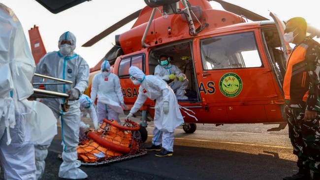 This handout photo taken and released on September 20, 2026 by Indonesia's Search and Rescue Agency (BASARNAS) shows rescue officials carrying body bags with the remains of victims recovered from the Virgo Transport 8 ship accident, upon arrival by h