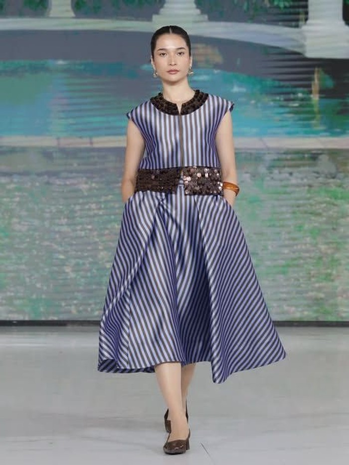 Koleksi yang satu ini cocok dikenakan untuk dinner atau pesta. Atasan tanpa lengan dibuat glamor dengan tambahan ornamen manik-manik yang terlihat mengkilap. Lalu, dipadukan dengan skirt A-line dengan warna senada.&nbsp;(Foto: Dok. Senayan City)