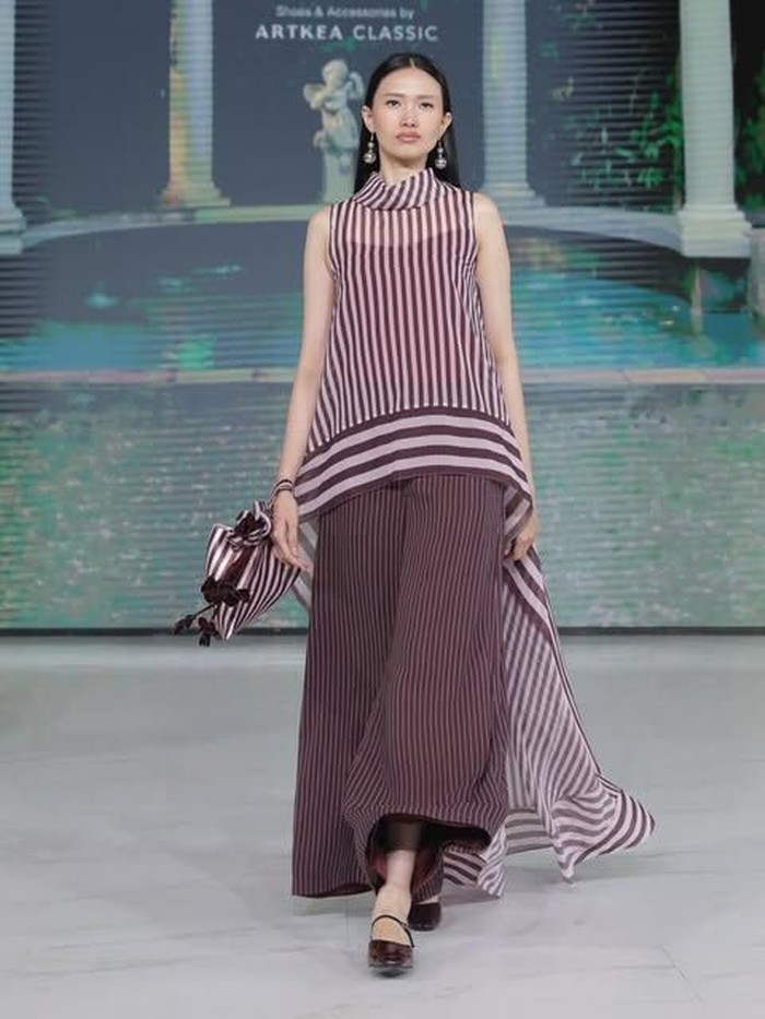 Koleksi Artkea Stripes yang menarik lainnya adalah koleksi berwarna plum ini. Tampak depan, terlihat simple hanya loose pants dan atasan tanpa lengan. Namun sebenarnya, atasan tersebut memiliki ekor panjang. Koleksi ini menampilkan kesan simple, feminin, tapi tetap stand out.&nbsp;(Foto: Dok. Senayan City)