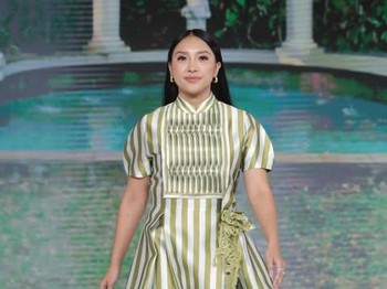 Tak kalah menarik, dibawakan oleh Afifah Yusuf, koleksi ini memiliki tampilan yang simple dan soft dengan warna hijau-putihnya. Bagian dada memiliki motif garis vertikal yang lebih rapat, lengan dress dibuat sedikit mengembang, dan rok melebar dengan panjang midi. Koleksi ini menampilkan kesan feminin dan playful dengan aksen pita di pinggang.&nbsp;(Foto: Dok. Senayan City)