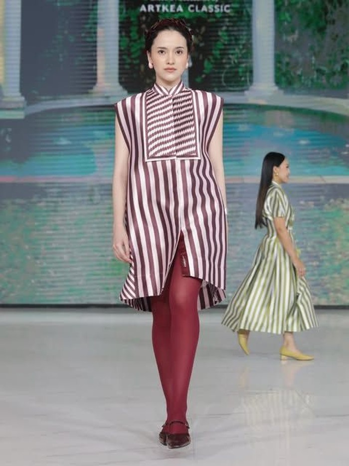 Salah satu koleksinya ini, menampilkan gaya yang lebih simple untuk sehari-hari. Dress berwarna maroon dan putih, dengan potongan lurus di atas lutut. Lalu, dipadukan dengan stocking berwarna senaga yang membuat tampilannya terlihat jenjang, elegan, dan statement.&nbsp;(Foto: Dok. Senayan City)