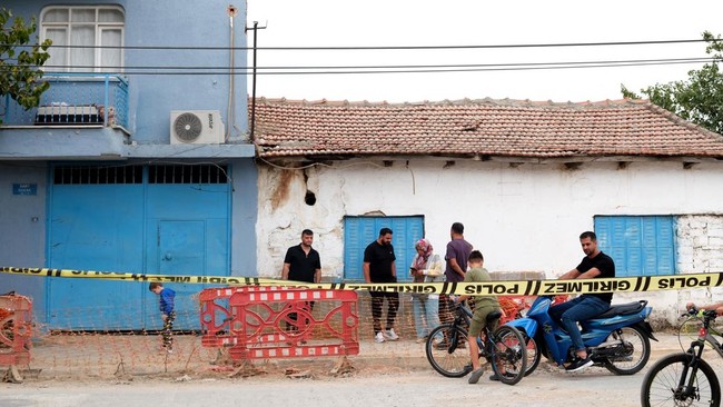 Members of the public stand behind a police cordon a high school where a gunman opened fire wounding eleven people and was detained shortly afterwards, in Turgutlu, an area west of the resort city of Izmir, on September 22, 2026. A teenager opened fi