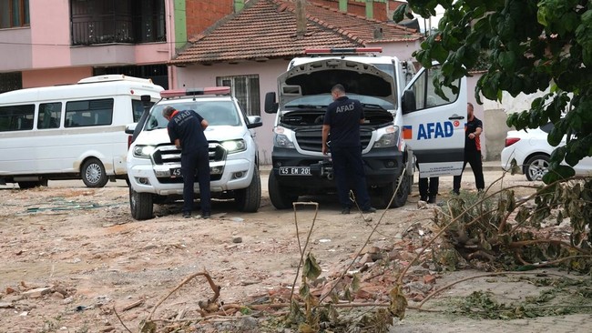 Vehicles and members of Turkish disaster relief agency AFAD wait in front of a high school where a gunman opened fire wounding eleven people and was detained shortly afterwards, in Turgutlu, an area west of the resort city of Izmir, on September 22,