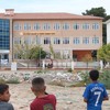Children look at a high school where a gunman opened fire wounding eleven people and was detained shortly afterwards, in Turgutlu, an area west of the resort city of Izmir, on September 22, 2026. A teenager opened fire outside a high school in wester