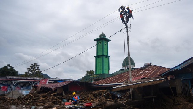 Pekerja memperbaiki jaringan listrik pascabanjir bandang di kawasan Arosuka, Kabupaten Solok, Sumatera Barat, Selasa (22/9/2026).