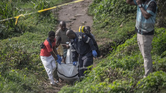 South African forensic pathology personnel are assisted by community members to carry the body of a victim following a mass shooting in the Ziko area of KwaMakhutha, south of Durban on September 23, 2026. Armed men stormed a home in the South African
