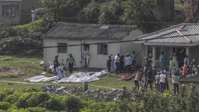 South African forensic investigators clear members of the community to conduct an investigation at the scene of a mass shooting in the Ziko area of KwaMakhutha, south of Durban on September 23, 2026. Armed men stormed a home in the South African city