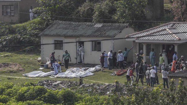 South African forensic investigators clear members of the community to conduct an investigation at the scene of a mass shooting in the Ziko area of KwaMakhutha, south of Durban on September 23, 2026. Armed men stormed a home in the South African city